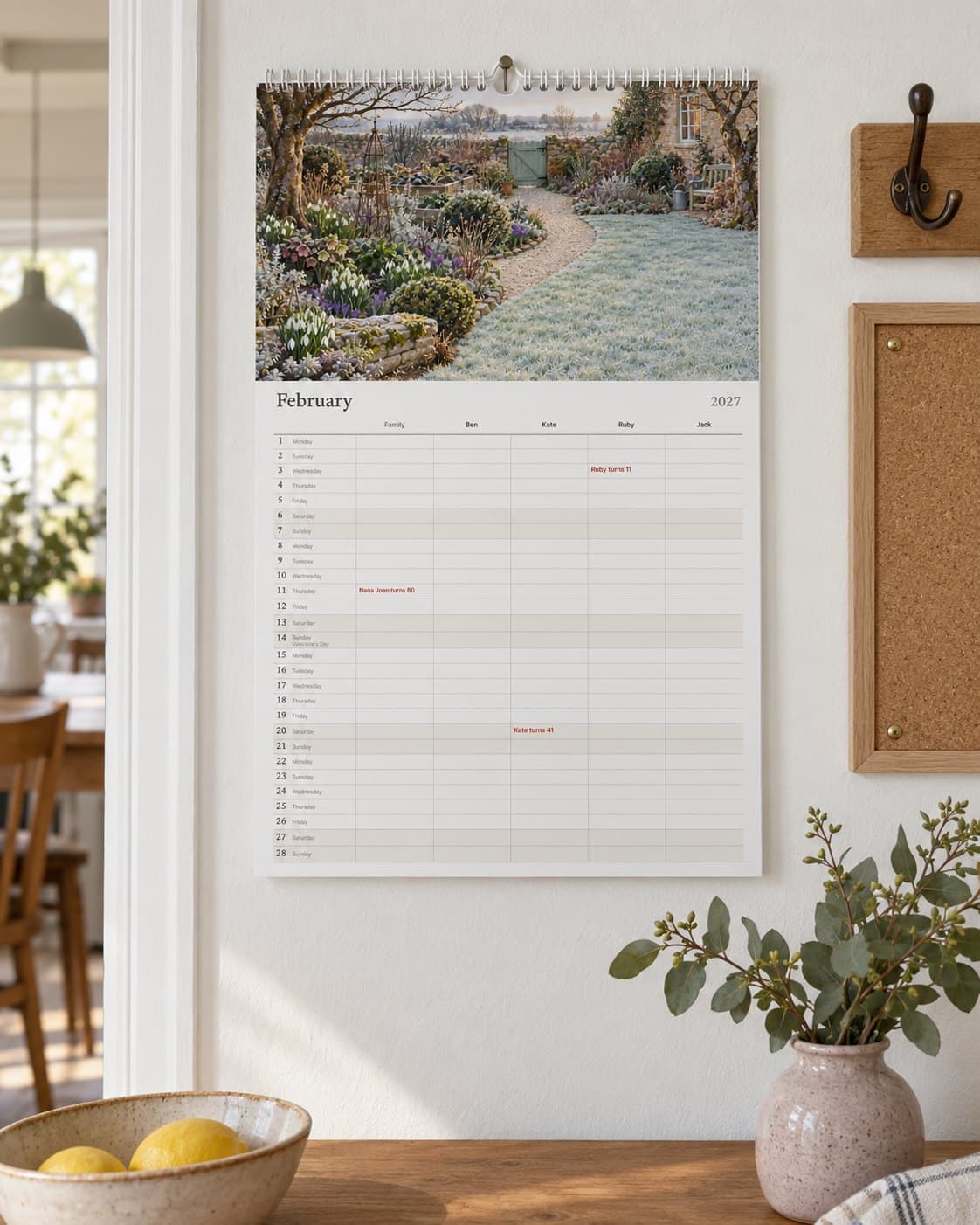 The family calendar with a column for each person, hanging in a kitchen