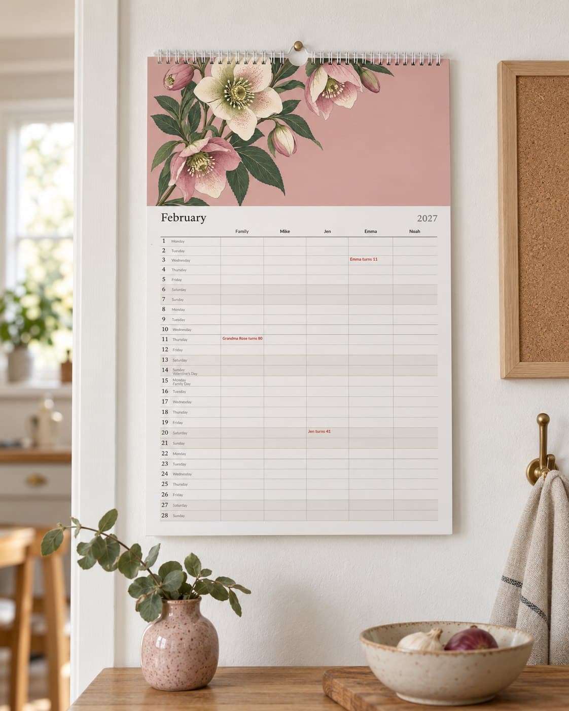 The family calendar with a column for each person, hanging in a kitchen