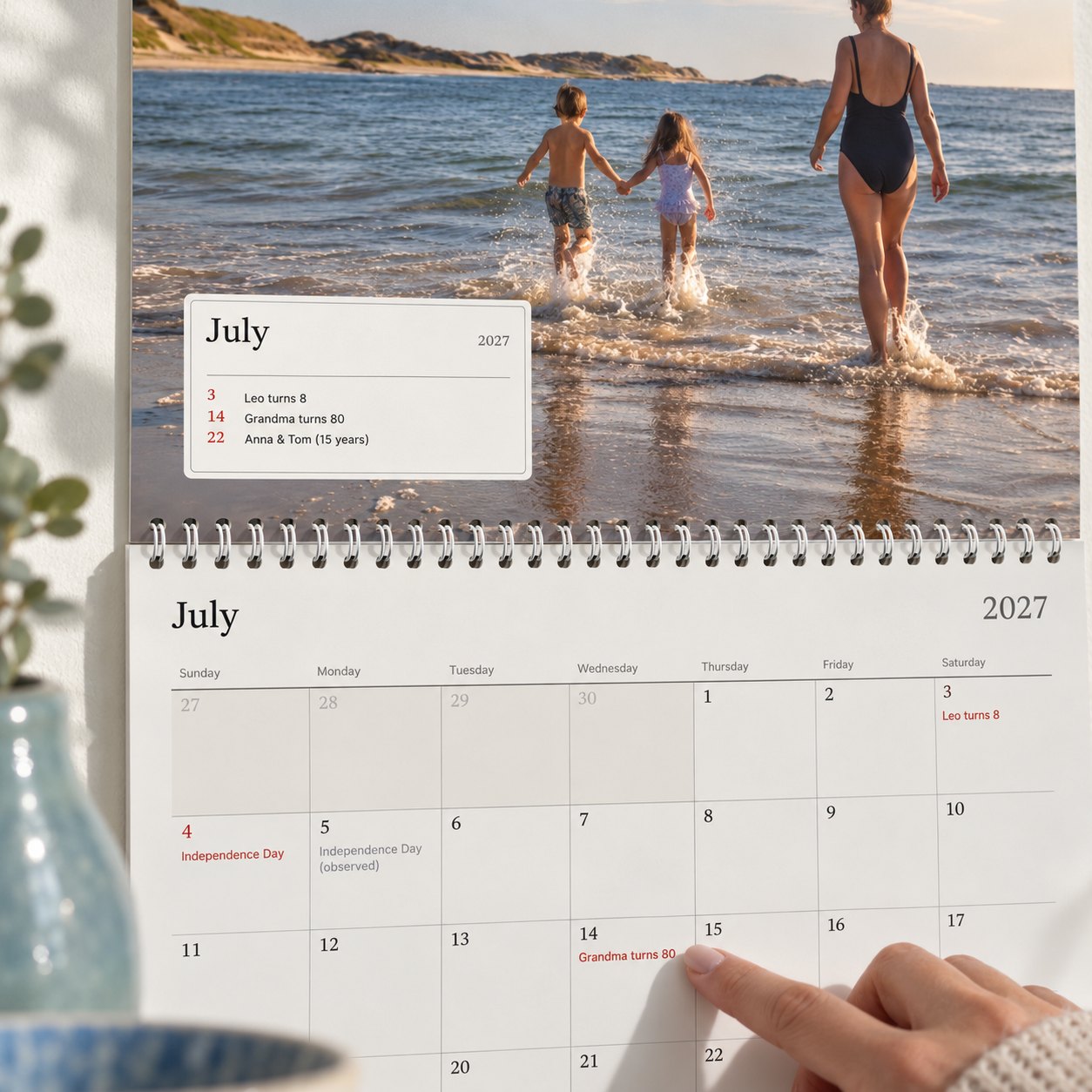 Close-up of the photo calendar: the month's box lists who is celebrating, and a finger points to grandma's 80th